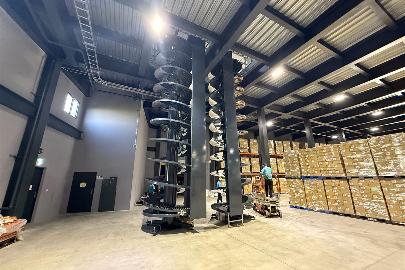 NEXUS spiral conveyors installed and running in a distribution centre, rising the full height of the building.