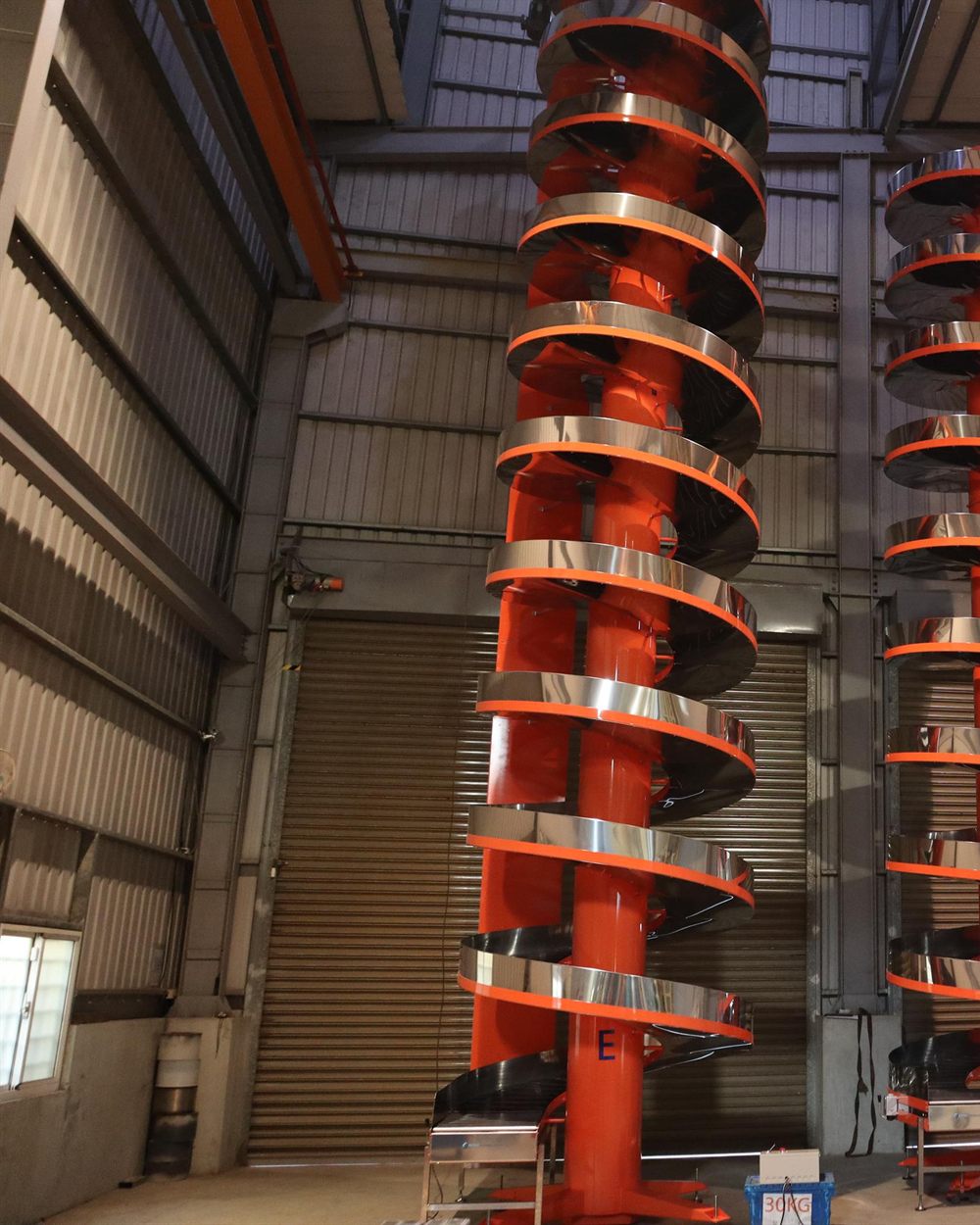 Cartons riding a spiral conveyor through a factory.