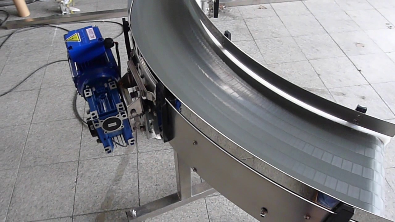 A stainless steel curve conveyor with a blue gearmotor at one end.