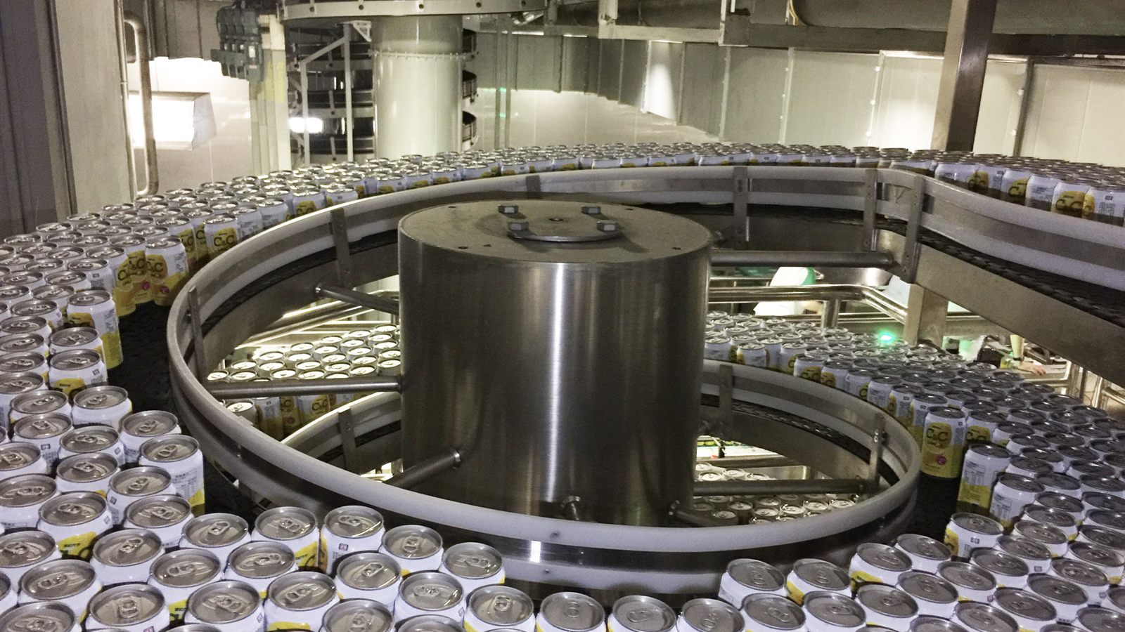 Beverage cans accumulating on a wide NEXUS spiral conveyor track.