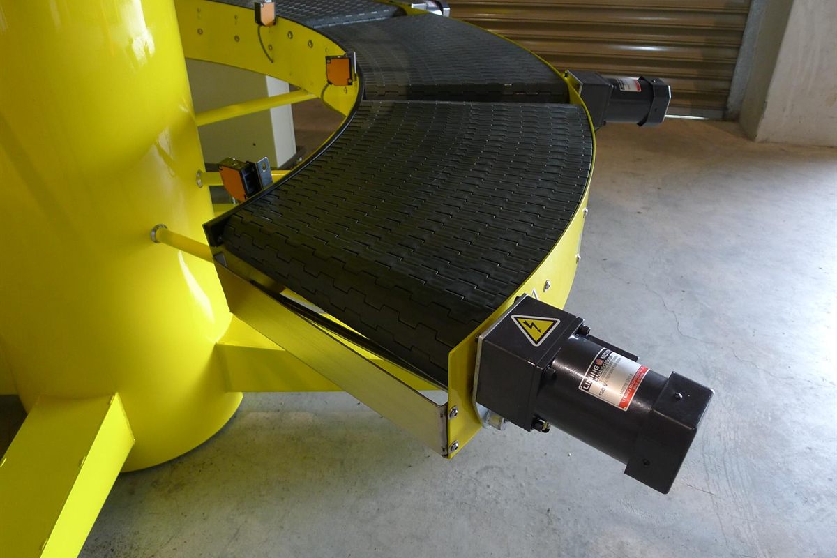 One yellow curved conveying unit of the Zone-Controlled Spiral Buffer with its gearmotor, beside the central column.