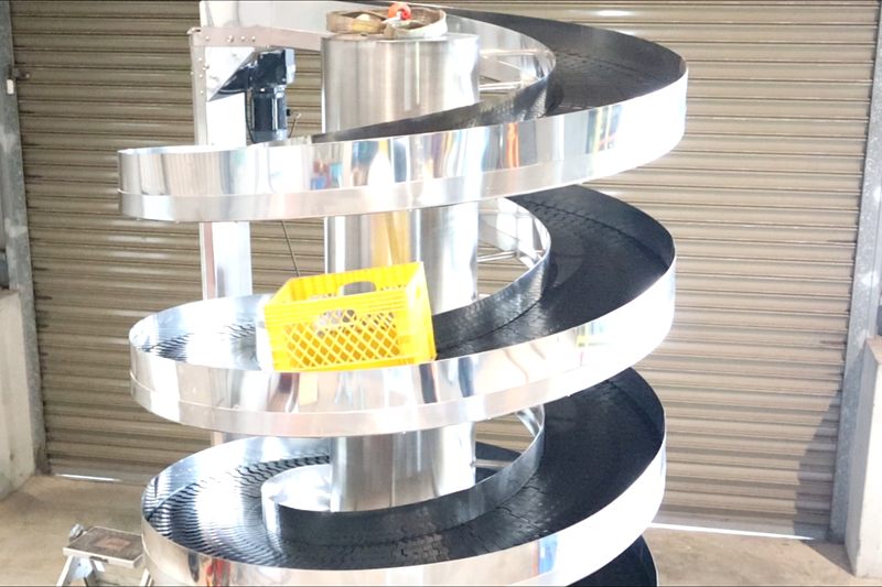 Plastic crates on a spiral conveyor track in the NEXUS factory.